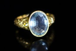 A Victorian style gold and single stone oval cut aquamarine dress ring,with carved shoulders, size