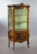 A Louis XV style mahogany vitrine,of serpentine form with a shelved interior above vignettes