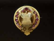 A Victorian gold and garnet set circular 'buckle' brooch,set with thirteen graduated oval cut