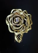 A 1980's French Cartier textured 18ct gold and diamond set 'open rose' clip brooch,numbered 9453,