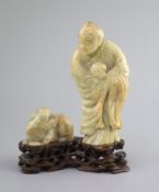 A Chinese soapstone group of a luohan and a lion dog, possibly 17th/18th century,the figure holding