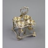 A George IV silver square egg cruet by Joseph Angel I,with four cups and shell and gadrooned