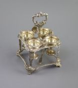 A George IV silver square egg cruet by Joseph Angel I,with four cups and shell and gadrooned