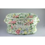 A Victorian ironstone two handled footbath, c.1840,green printed and over enamelled with pink