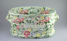 A Victorian ironstone two handled footbath, c.1840,green printed and over enamelled with pink