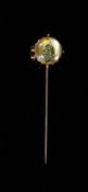 A late 19th century French 18ct gold and Essex crystal stick pin decorated with jockeys colours,