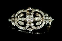 An Edwardian gold, silver and diamond set openwork oval brooch,the central stone weighing