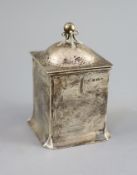 An Edwardian Art Nouveau silver tea caddy by Connell,of square form, with planished cover and ball