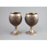 A pair of George III silver mounted coconut cups by Phipps & Robinsoncarved with rams head crests