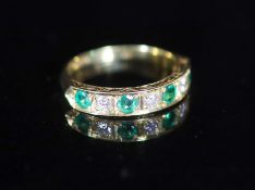 A modern 18ct gold, four stone emerald and three stone diamond set half hoop ring,with carved