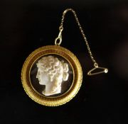 A Victorian gold and white enamel mounted agate cameo circular pendant brooch,carved with the head