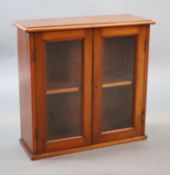 A small Edwardian mahogany wall cabinet,with two glazed doors,W.58cm D.21cm H.57cm The Royal