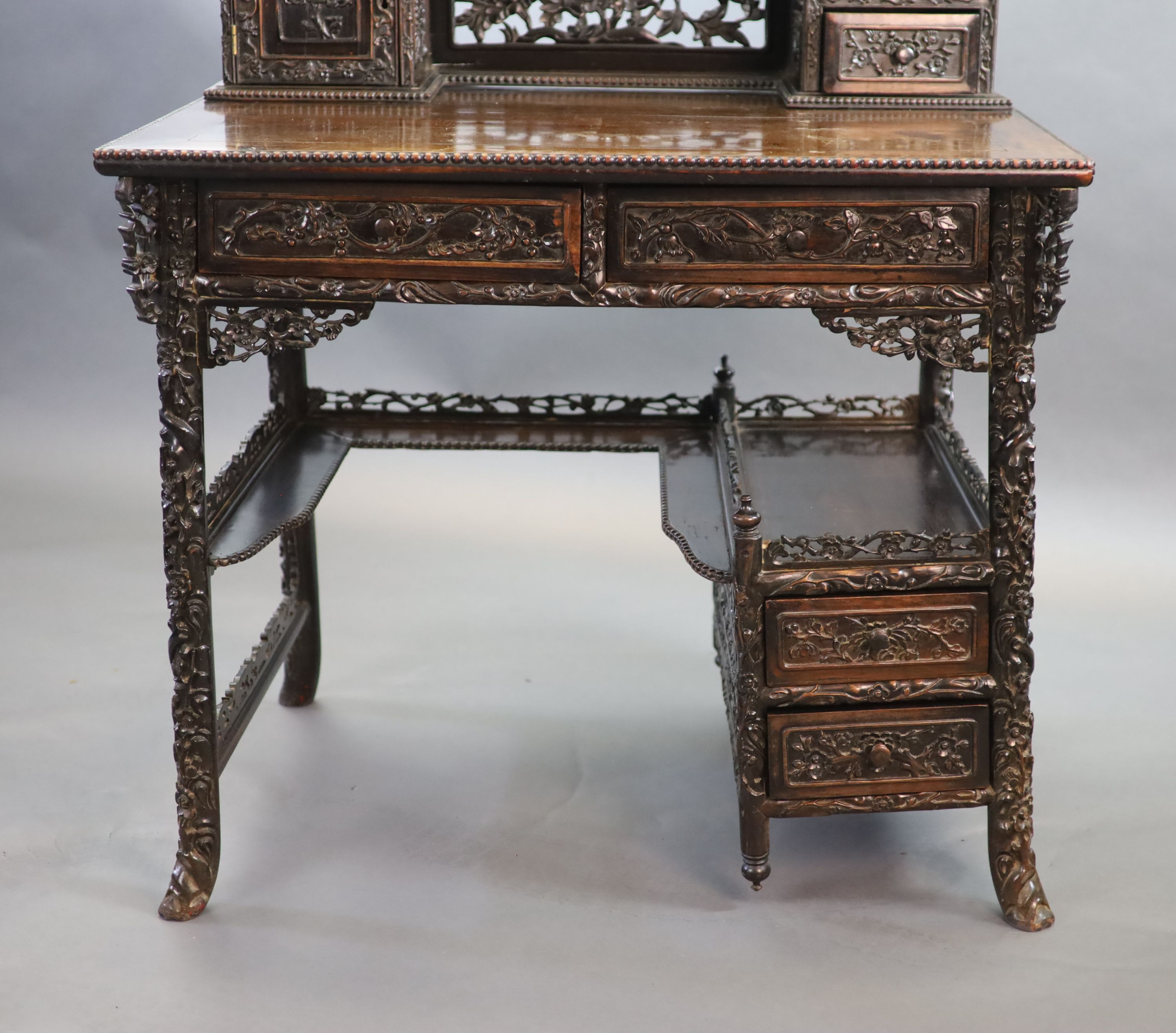 A late 19th century Chinese hongmu desk,carved and pierced throughout with flowers, the raised - Image 2 of 4