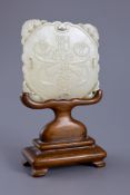 A Chinese pale celadon jade plaque, 19th century,one side carved in relief with a pair of ribbon
