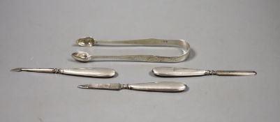 A pair of Georgian silver sugar tongs and three manicure implements.