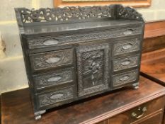 An Edwardian chinoiserie inspired ebonised oak table top cabinet, with cupboard and seven drawers,