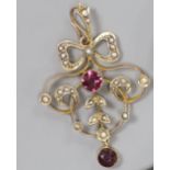 An early 20th century 9ct, garnet and seed pearl set openwork pendant,overall 4cm, gross weight 2.6