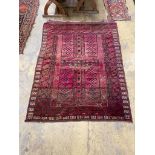A Belouch burgundy ground rug, 190 x 150cm