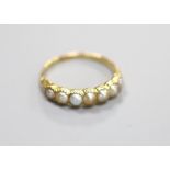 A late Victorian yellow metal and split pearl set half hoop ring,shank repaired, size O, gross