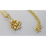 A modern yellow metal and three stone diamond set rustic pendant, 15mm, on a 18ct chain, 45cm,gross