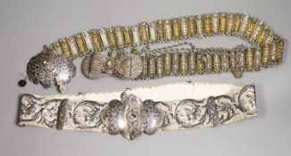 A white metal and niello belt buckle, one other on a sash belt and a filigree white metal belt.