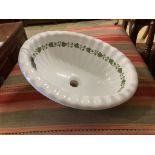 A ceramic shell sink with green ivy detail, width 52cm, depth 42cm
