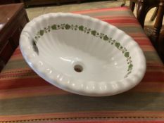 A ceramic shell sink with green ivy detail, width 52cm, depth 42cm