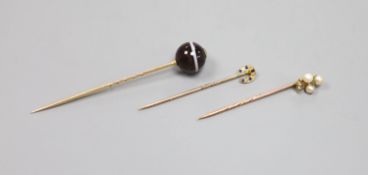 Three assorted early 20th century yellow metal and gem set stick pins,including banded agate,