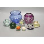 A group of coloured glassware including paperweights