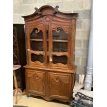 A 19th century French stained pine vitrine, with two glazed doors over panelled doors, width 133cm