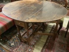 A mid 18th century oak oval topped gate leg dining table, fitted two drawers, width 142cm extended,