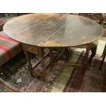 A mid 18th century oak oval topped gate leg dining table, fitted two drawers, width 142cm extended,