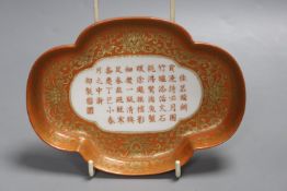 A Chinese coral ground inscribed dish, width 18cm