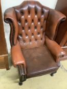 A buttoned burgundy leather wing armchair, width 86cm, depth 80cm, height 110cm