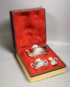 A cased late 19th/early 20th century French demi fluted white metal three piece tea set, by Edmond