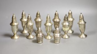 A set of nine weighted sterling pepperettes, 12.5cm and two smaller similar pepperettes.