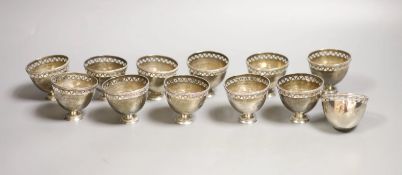 A set of twelve pierced small white metal footed cups,height 5cm, 13oz.