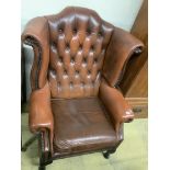 A buttoned burgundy leather wing armchair, width 86cm, depth 80cm, height 110cm