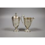 A George V silver helmet shaped cream jug, 12cm a silver sugar caster and a sifter spoon,7oz.