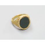 A modern 9ct gold and bloodstone set oval signet ring, with textured setting, size Q,gross 10.7