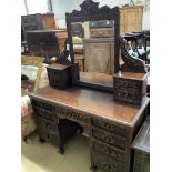 A late 19th century Flemish carveed oak kneehole dressing table, width 136cm depth 56cm height