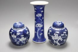Two Chinese blue and white prunus pattern ginger jars and a similar cylinder vase, tallest 26cm
