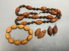 A Chinese peach stone or nut bead necklace, bracelet, a pair of earrings and two carved beads