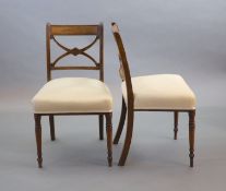 A set of six Regency mahogany dining chairs,with X shaped backs and upholstered seats, on turned