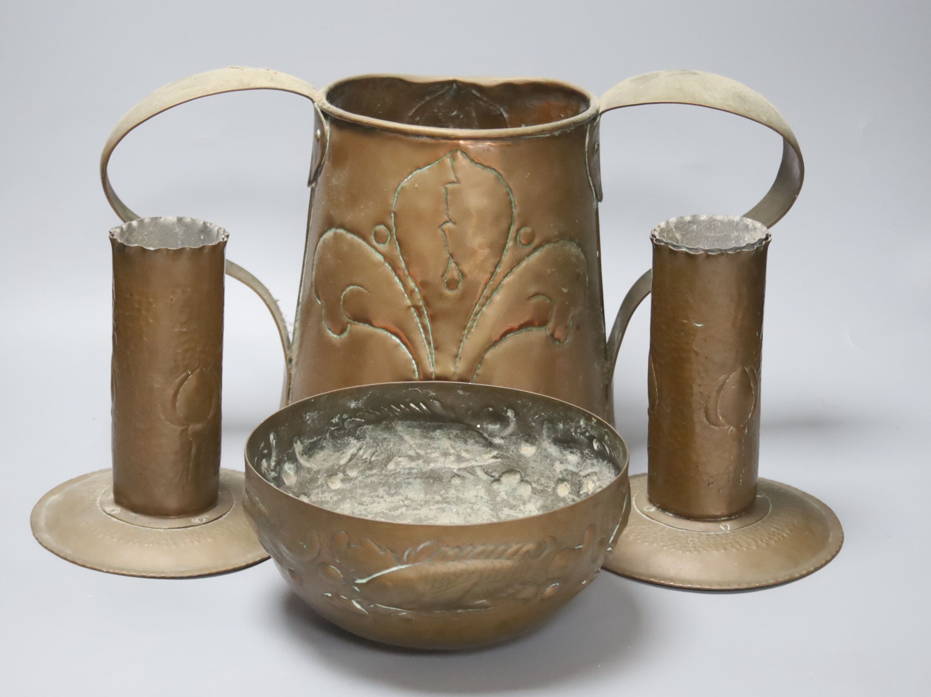 A Newlyn copper 'fish' bowl, together with a pair of Art Nouveau planished copper candlesticks and