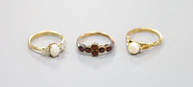 A 9ct yellow gold garnet-set ring, a similar cabochon opal and small diamond ring and a similar