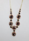 A 20th century 585 yellow metal and garnet cluster set necklace,44cm, gross weight 24.8 grams.