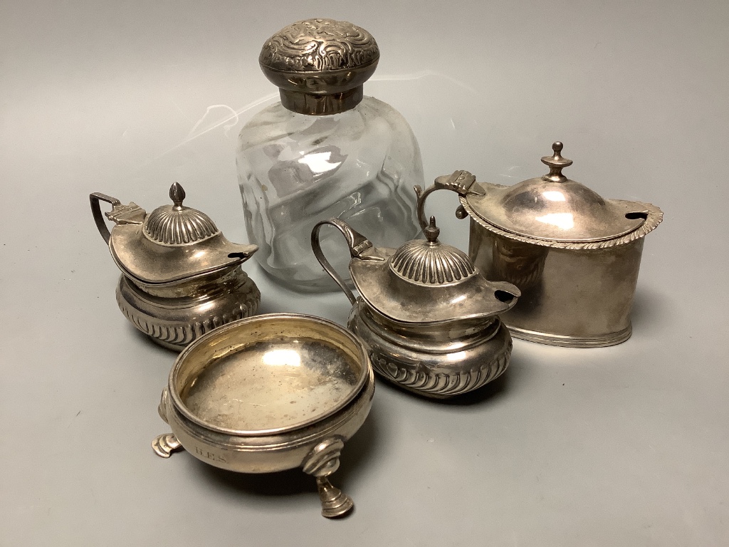 Three assorted silver mustard pots, a silver mounted glass scent bottle and Georgian silver salt.