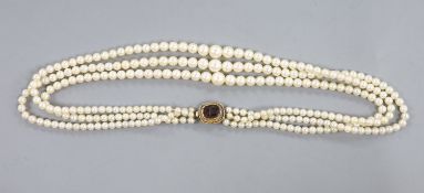 A triple strand graduated cultured pearl choker necklace, with yellow metal and garnet(cracked) set