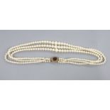 A triple strand graduated cultured pearl choker necklace, with yellow metal and garnet(cracked) set